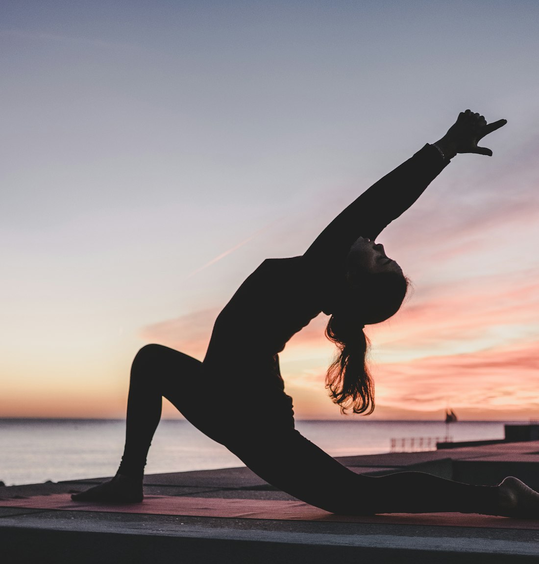 Silhouette en posture de yoga au couchant